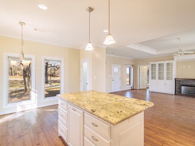 kitchen featuring a fireplace, hardwood / wood-style floors, ceiling fan, and decorative light fixtures