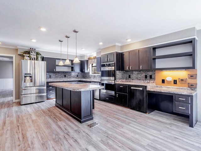 kitchen with pendant lighting, dark brown cabinets, light hardwood / wood-style flooring, stainless steel appliances, and a center island