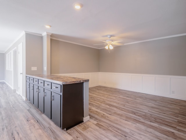 kitchen featuring light wood-type flooring, crown molding, kitchen peninsula, and ceiling fan