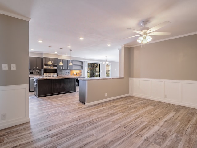 kitchen with decorative backsplash, ceiling fan with notable chandelier, crown molding, light hardwood / wood-style flooring, and decorative light fixtures