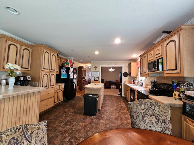 kitchen with a center island, sink, a notable chandelier, crown molding, and black appliances