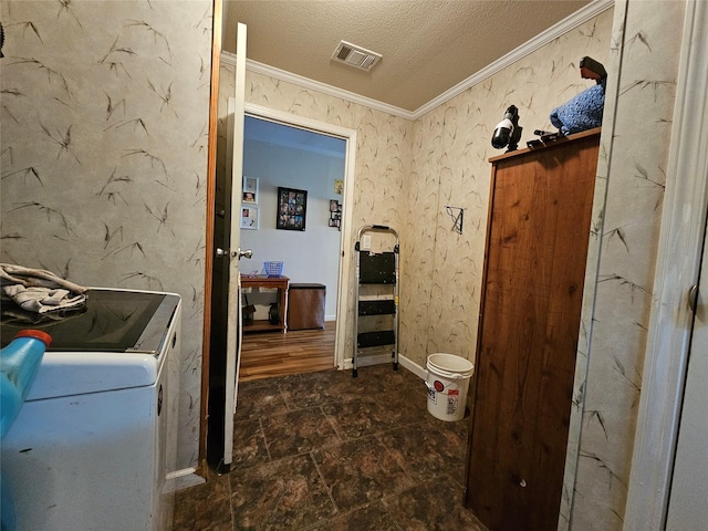 bathroom featuring washer and dryer, a textured ceiling, and crown molding