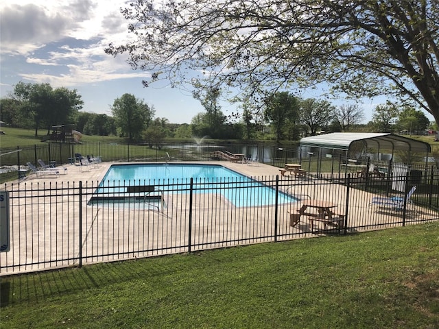 view of swimming pool with a lawn, a patio area, and a water view