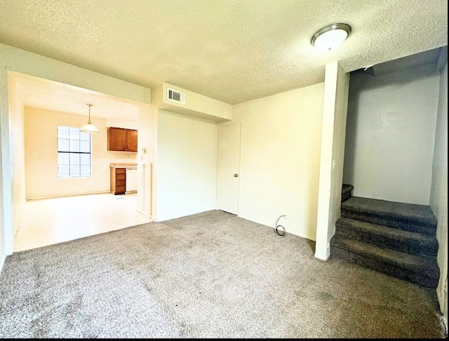 unfurnished living room featuring light carpet and a textured ceiling