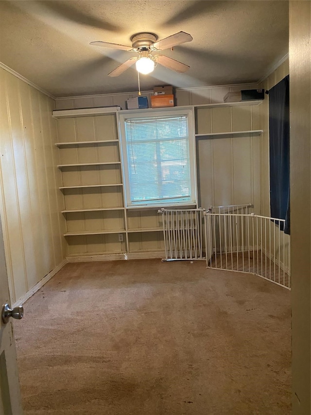 carpeted spare room featuring ceiling fan and a textured ceiling