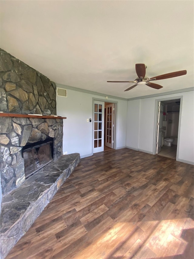 unfurnished living room with french doors, ceiling fan, a stone fireplace, and hardwood / wood-style flooring