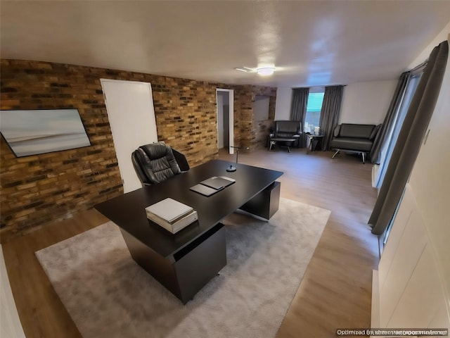 living room with hardwood / wood-style flooring and brick wall