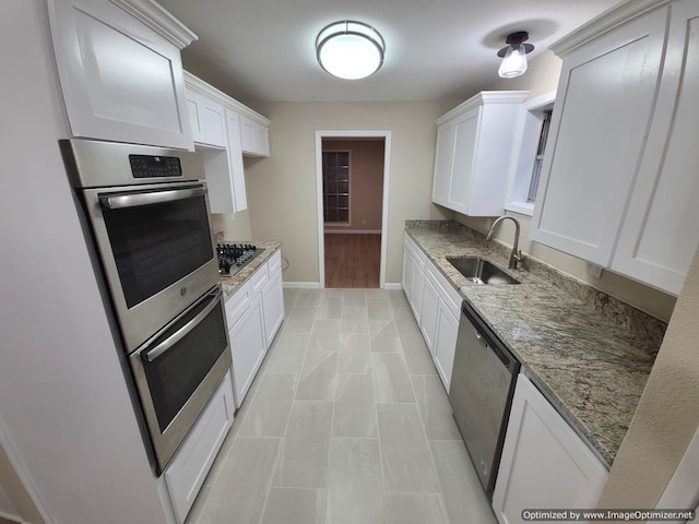 kitchen with white cabinetry, sink, stainless steel appliances, and stone countertops