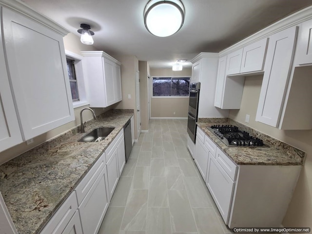 kitchen featuring light stone counters, sink, white cabinets, and appliances with stainless steel finishes