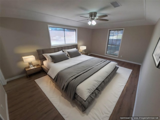 bedroom with dark hardwood / wood-style floors and ceiling fan