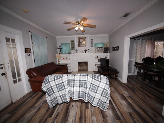 living room with ceiling fan, dark hardwood / wood-style flooring, ornamental molding, and a brick fireplace