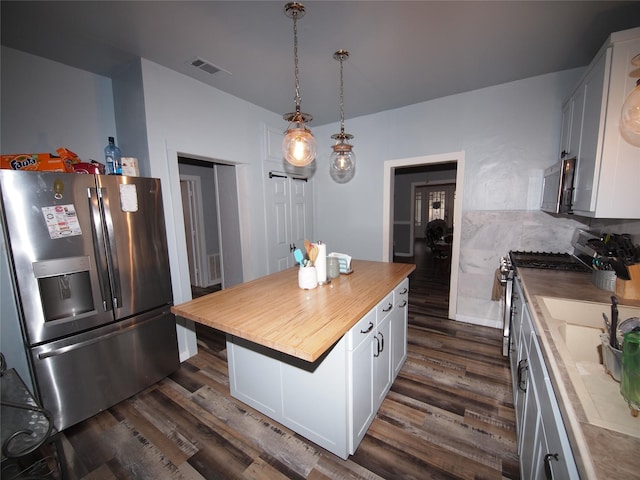 kitchen with a center island, dark hardwood / wood-style flooring, white cabinetry, and appliances with stainless steel finishes