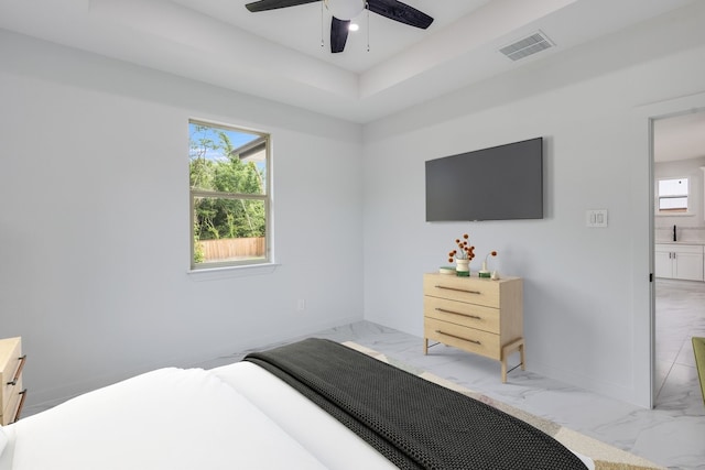 bedroom featuring a raised ceiling, ceiling fan, and light tile floors