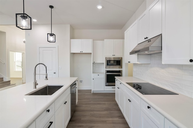 kitchen featuring decorative light fixtures, appliances with stainless steel finishes, white cabinetry, a sink, and under cabinet range hood