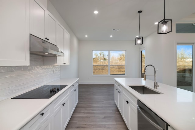 kitchen featuring light countertops, a sink, dishwasher, under cabinet range hood, and black electric cooktop