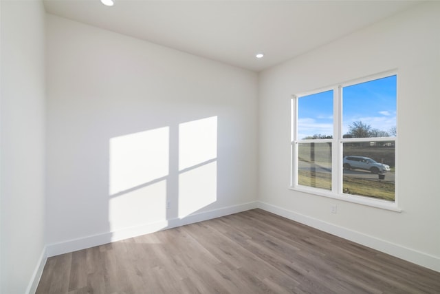 empty room featuring baseboards, wood finished floors, and recessed lighting