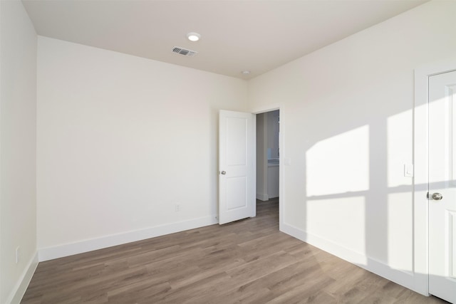 unfurnished bedroom with visible vents, light wood-style flooring, and baseboards