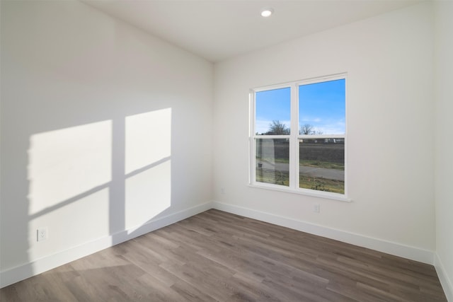 empty room featuring baseboards, wood finished floors, and recessed lighting