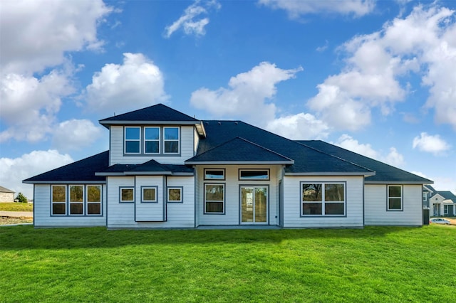 rear view of house featuring a yard