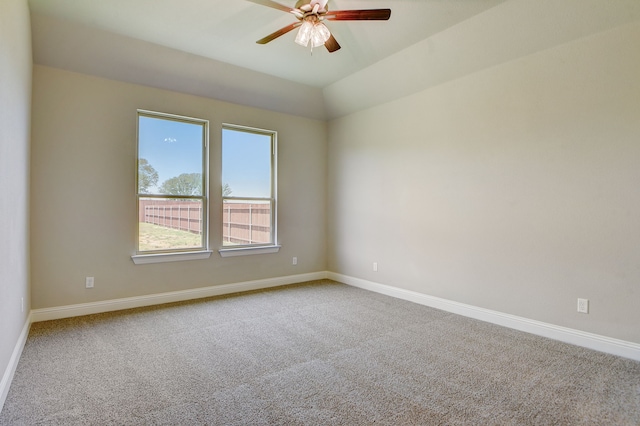 carpeted spare room featuring vaulted ceiling and ceiling fan