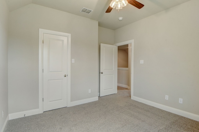 unfurnished bedroom with light carpet, vaulted ceiling, and ceiling fan