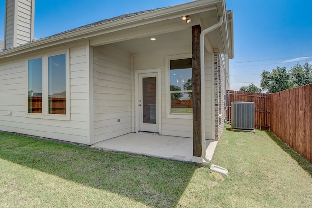 property entrance featuring a yard, central air condition unit, and a patio