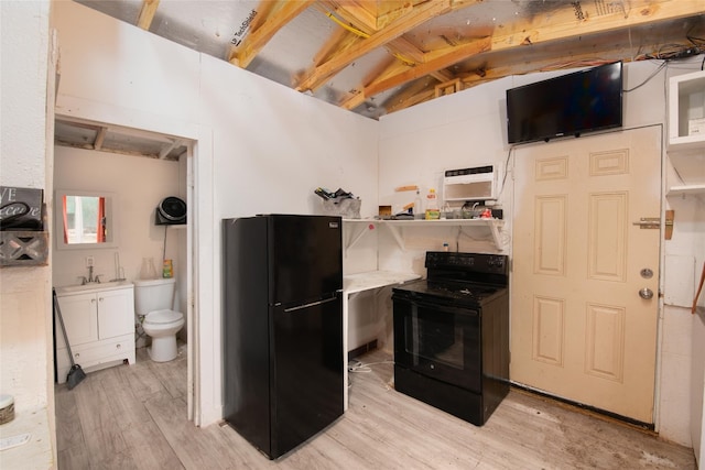 kitchen with beam ceiling, black appliances, sink, and light wood-type flooring