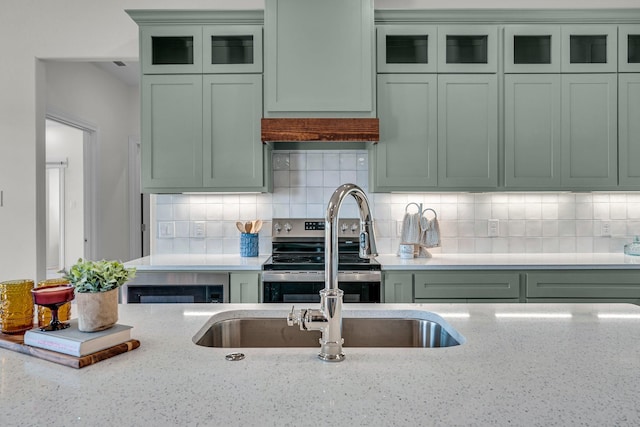 227 Rio Grande, Abilene, TX 79606 - kitchen featuring green cabinets, electric range, tasteful backsplash, and light stone countertops