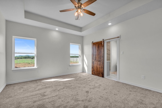 227 Rio Grande, Abilene, TX 79606 - unfurnished bedroom featuring carpet, a barn door, recessed lighting, a raised ceiling, and ceiling fan
