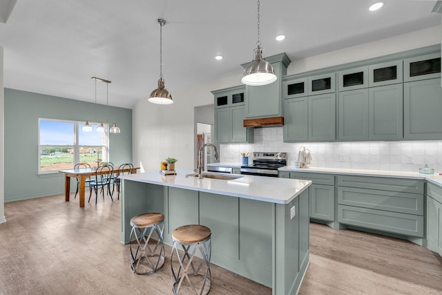 227 Rio Grande, Abilene, TX 79606 - kitchen featuring electric range, backsplash, a kitchen island with sink, light wood-style floors, and recessed lighting