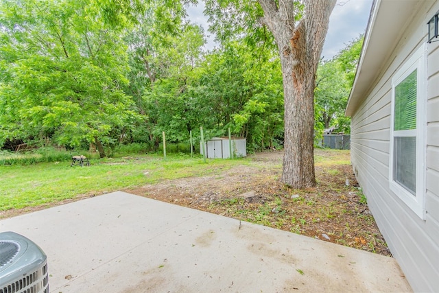 view of yard with central AC, a shed, and a patio