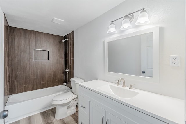 full bathroom featuring hardwood / wood-style flooring, vanity with extensive cabinet space, toilet, and tiled shower / bath