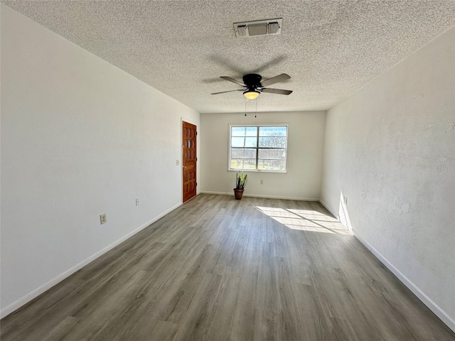 empty room with light hardwood / wood-style floors, ceiling fan, and a textured ceiling