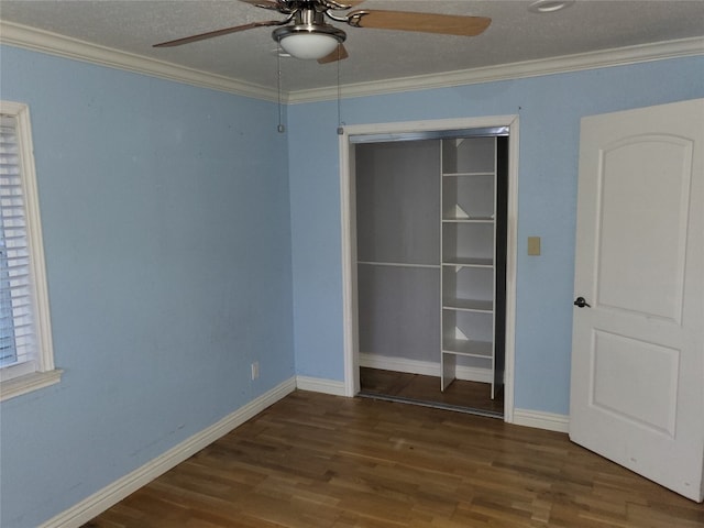 unfurnished bedroom featuring a closet, ceiling fan, crown molding, and dark wood-type flooring