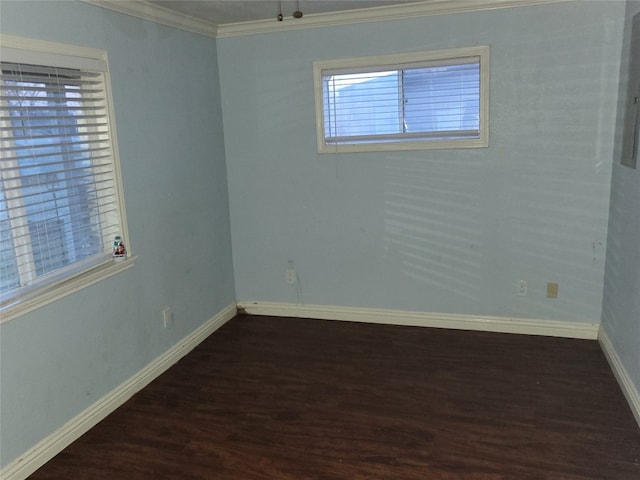 empty room with dark hardwood / wood-style flooring, plenty of natural light, and crown molding