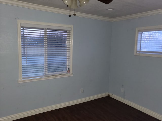 spare room featuring ceiling fan, plenty of natural light, ornamental molding, and dark wood-type flooring