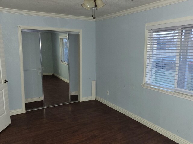 unfurnished bedroom featuring dark hardwood / wood-style floors, ceiling fan, ornamental molding, and a closet