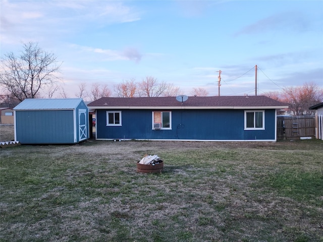 rear view of house with a storage shed and a yard