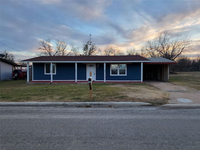 ranch-style house with a yard and a carport