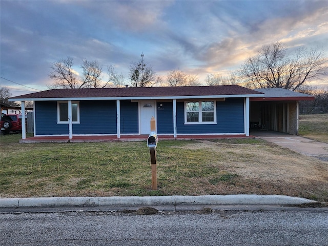 view of front of house featuring a lawn and a carport