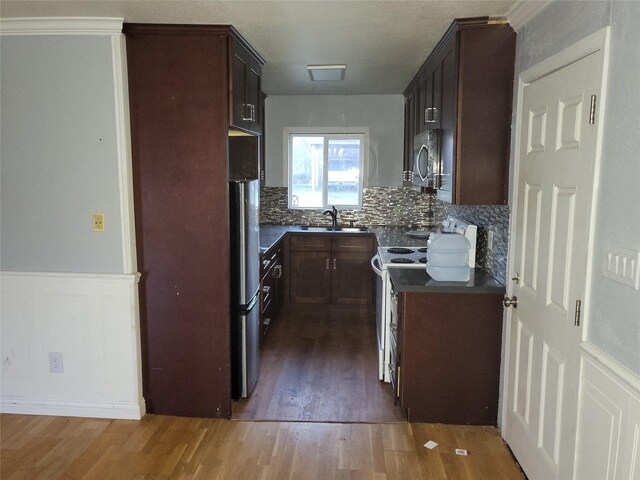 kitchen featuring backsplash, dark wood-type flooring, sink, dark brown cabinetry, and stainless steel appliances