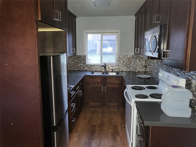 kitchen with dark hardwood / wood-style flooring, sink, backsplash, and appliances with stainless steel finishes