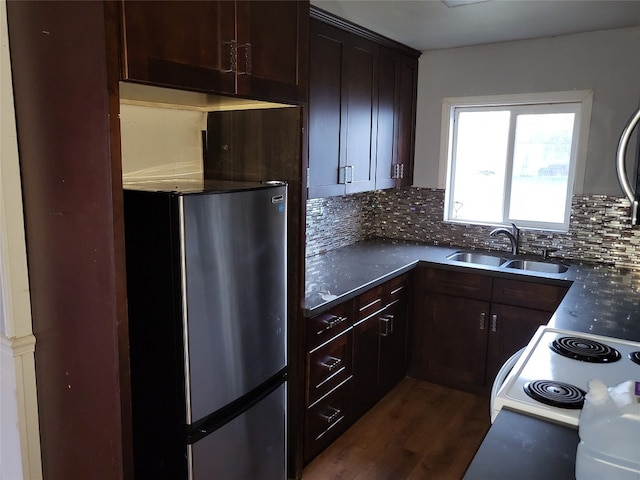 kitchen with sink, dark wood-type flooring, tasteful backsplash, range with electric stovetop, and stainless steel fridge