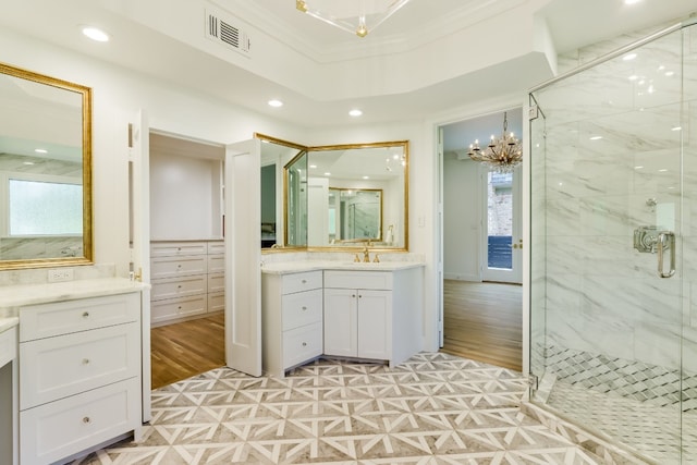 bathroom with crown molding, hardwood / wood-style floors, vanity, an enclosed shower, and a notable chandelier