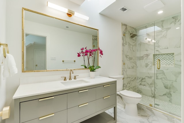 bathroom with vanity, toilet, and a shower with door