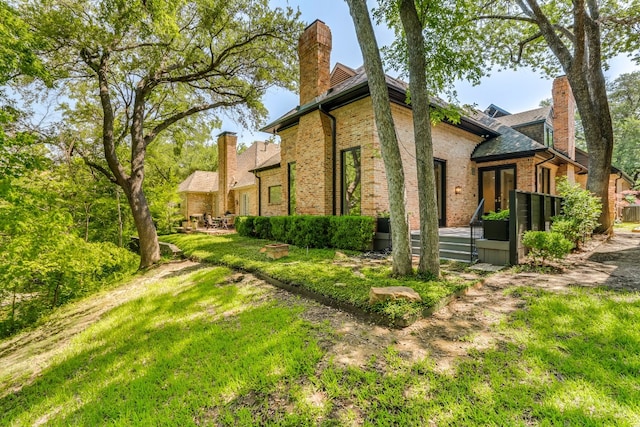 view of side of home with a yard