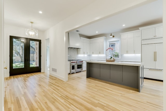 kitchen with white cabinetry, premium range hood, a center island, and premium appliances