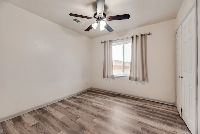 empty room with wood-type flooring and ceiling fan