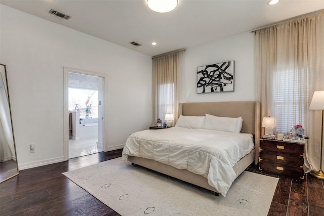 bedroom featuring ensuite bathroom and dark hardwood / wood-style flooring