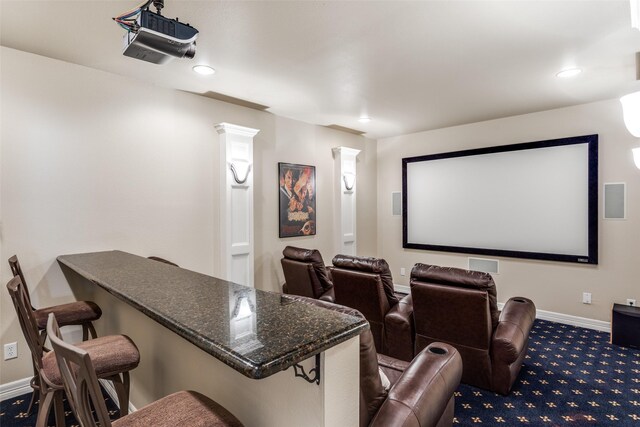 kitchen with dark hardwood / wood-style floors, beverage cooler, dark stone counters, and sink